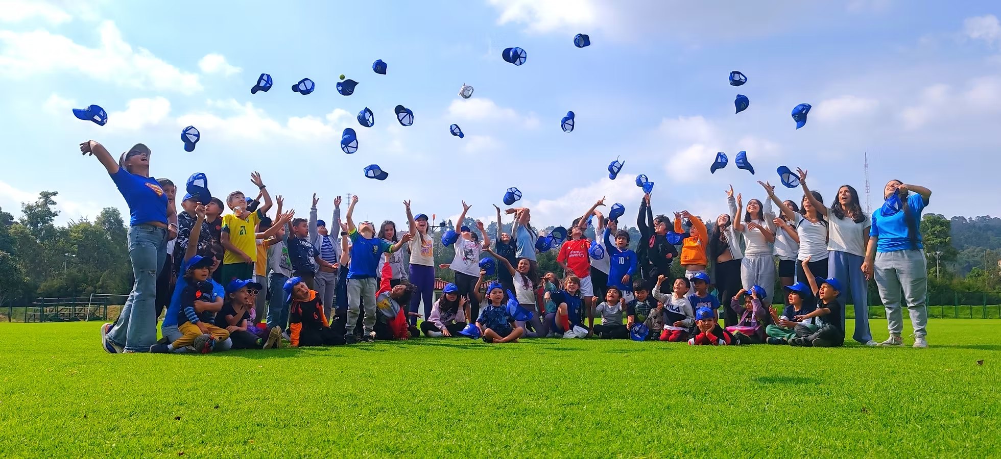Holiday camp group throwing their caps in the air on the court in Bogotá